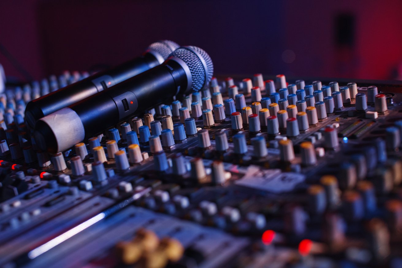 Soundman working on the mixing console in concert hall.