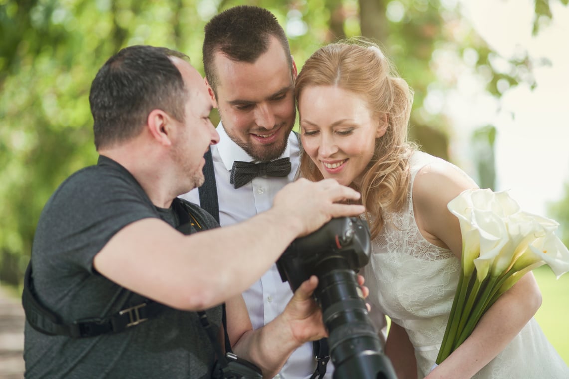 Wedding photographer showing the photos to the couple